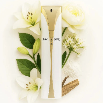 A white and gold cylindrical perfume bottle labeled 'BLANC BURI' is arranged on a white background with white flowers, green leaves, and a small vanilla bean. The product is centered and presented as a styled flat-lay.
